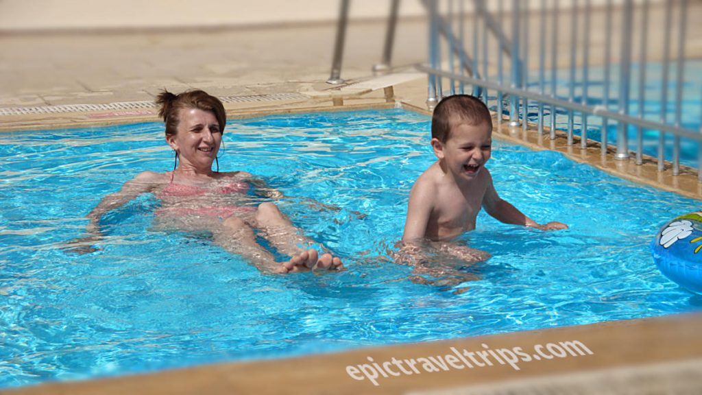 Boy and mom swims in the pool
