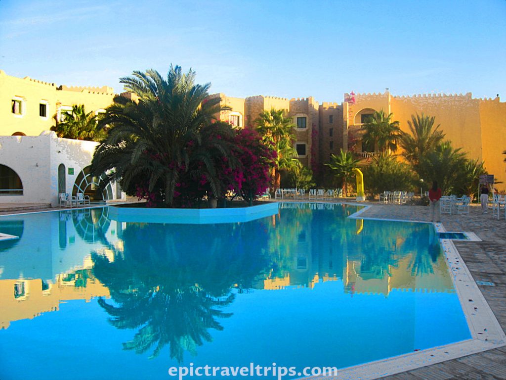 El Mouradi Hotel In Douz, Tunisia. Daylight photo around swimming pool and hotel at the back. Part of our Adventurous Three Days Epic Sahara Tour In Amazing Tunisia With Hidden Gems