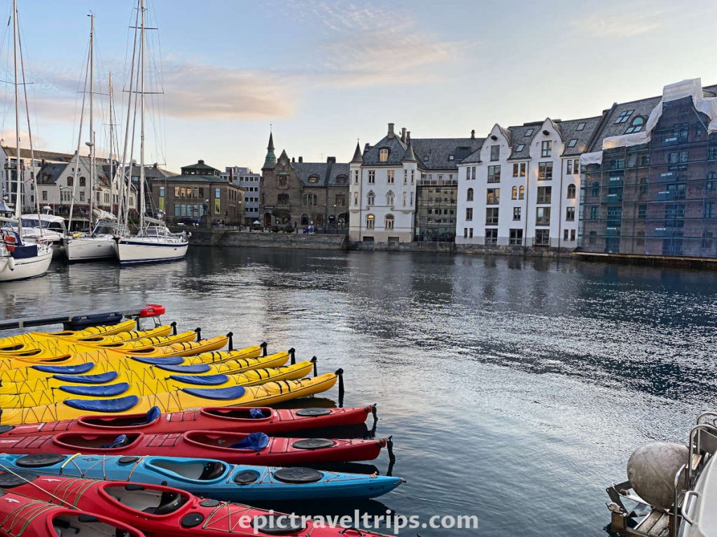 Ålesund port with yellow and red kayaks, yachts and buildings.