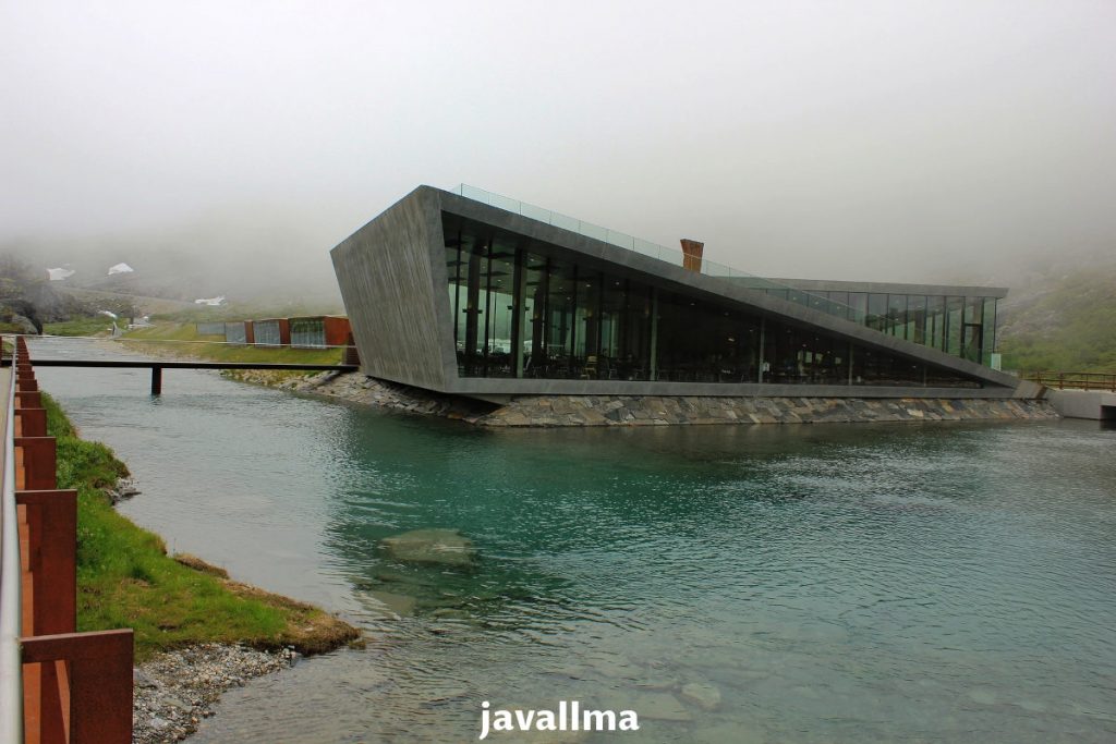 We see Trollstigen's visitors center with slope lines inspired by the mountain road slopes on a foggy day in Norway.