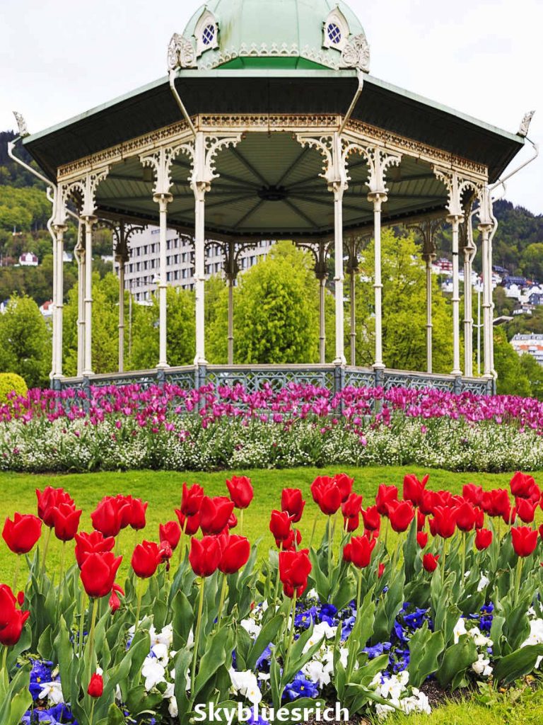 Bergen festplassen gazebo in Norway with different flowers in front of it.