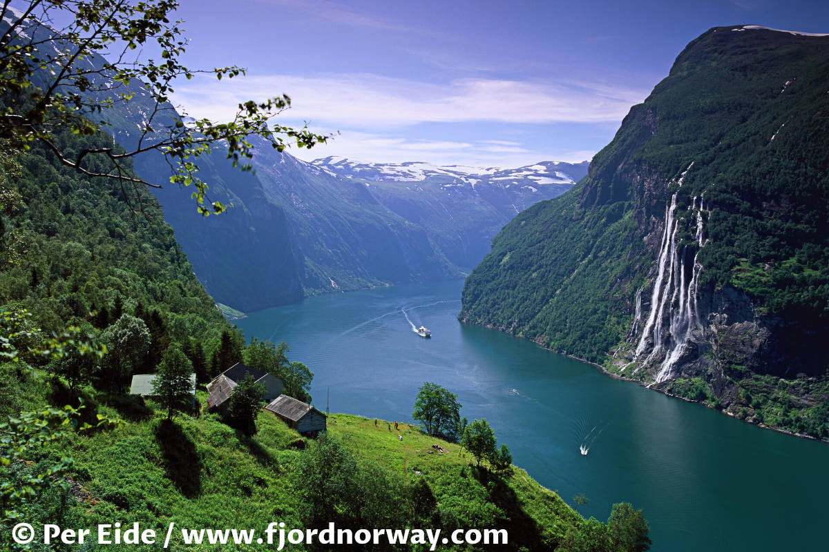 View over Geiranger fjord, cruise ships, and Seven Sisters waterfalls from Skageflå mountain farm in Norway.