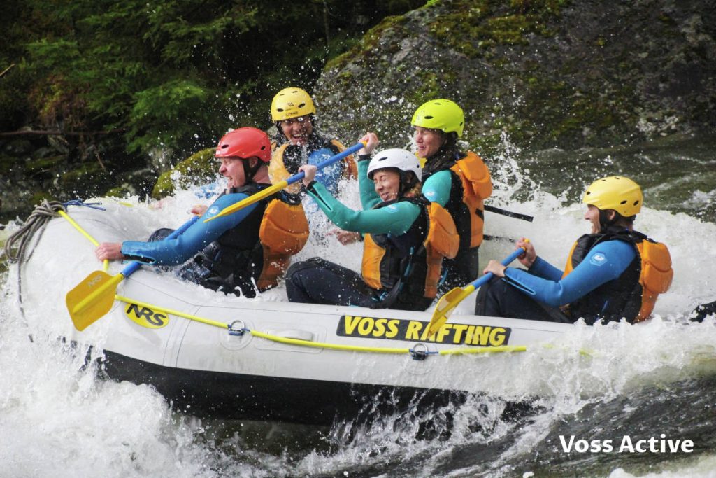 Five persons in the boat raft in the wild water near Voss in Norway.