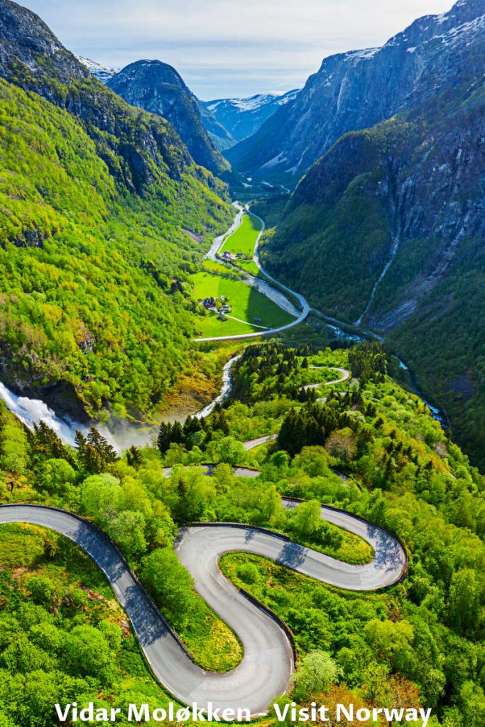Aerial view of Stalheimskleiva winding road in the valley of Naeroydalselvi river with surrounding mountains in Norway.