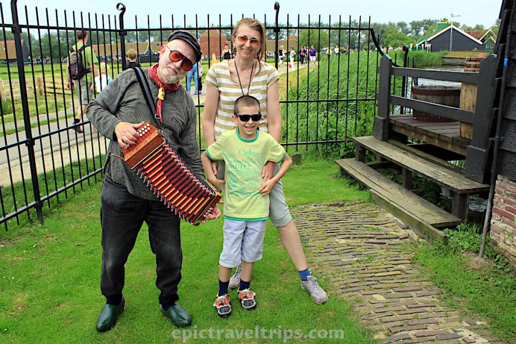 A man with an accordion entertains a boy and woman at Zaanse Schans in The Netherland.