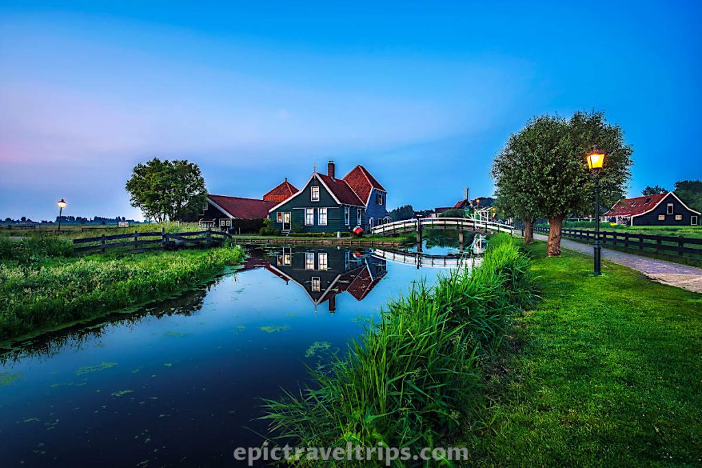 Sunset photo of a cheese farm with a white wooden bridge over the canal at Zaanse Schans in The Netherland