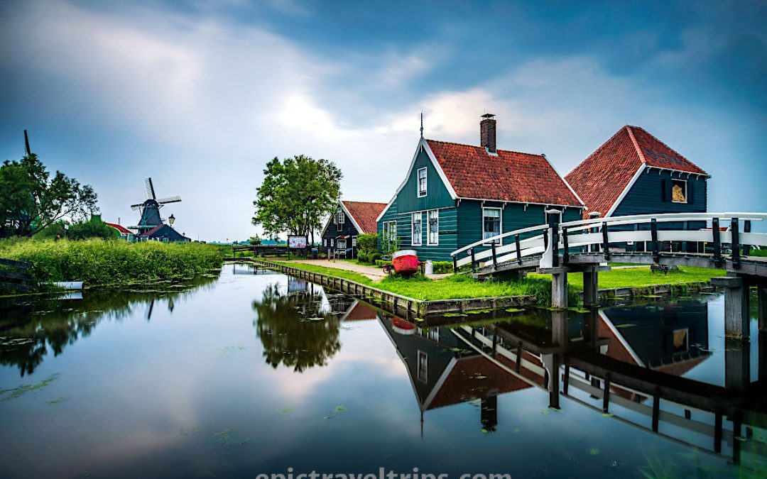 Long exposure to a cheese farm with a white bridge and windmills at the back in Zaanse Schans in The Netherland.